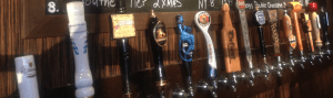 A row of beer taps on a wall.